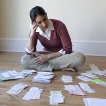 Woman looking at bills and receipts on floor