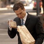 businessman Pulling Sandwich from Brown Paper Bag
