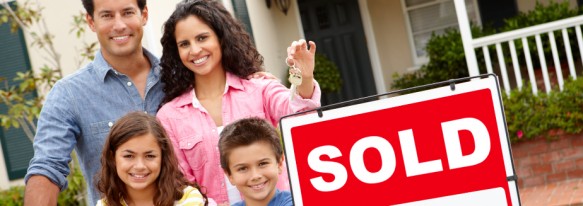 Hispanic family outside home with sold sign