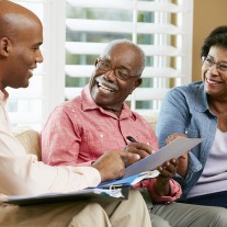 Financial Advisor Talking To Senior Couple At Home